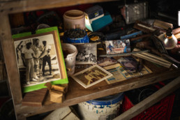 Photos, tools, and other paraphenalia on a wooden table in Ansil Saunders's workshop.