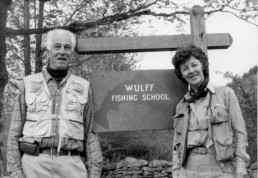 Lee and Joan Wulff stand on either side of the Wulff Fishing School sign.