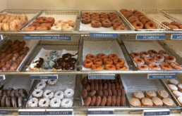 Three racks of donuts in various flavors.