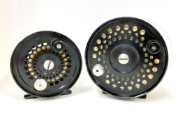 Two black fishing reels of different sizes.