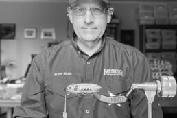 Scott Biron at his tying desk, a tied fly sitting in a vise in front of him.