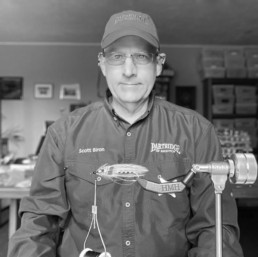 Scott Biron at his tying desk, a tied fly sitting in a vise in front of him.