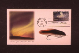 A postcard featuring a stamp and illustration both depicting the Aurora Borealis, along with a fly named after the phenomenon.