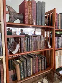 Rows of used books on shelves are bracketed by fish and book bookends.
