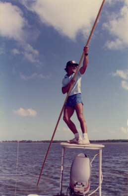 Jose Wejebe stands on a guide platform, using a pole to propel the boat.