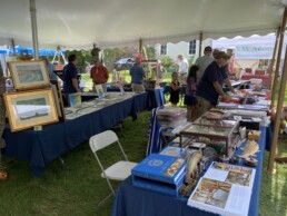 Paintings, books, and reels on display under the main tent.