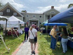 A festival attendee heads up the walkway towards the museum, taking a look at the vendor tents arrayed on either side of the path.